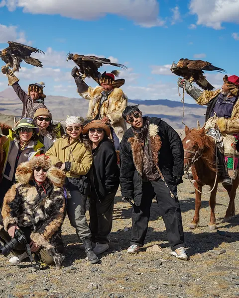 Eagle hunters and travelers with golden eagles in the Altai