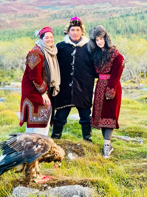 Travelers in traditional Kazakh dress with a golden eagle