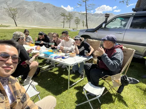 Shared lunch on the steppe beside the Land Cruisers