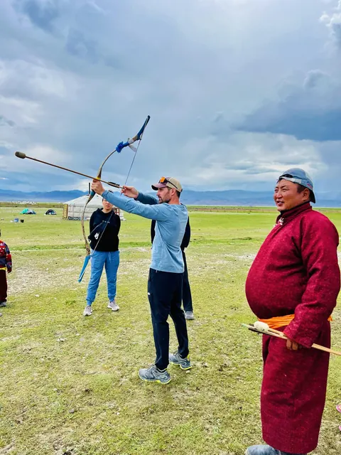 Trying traditional archery with a local