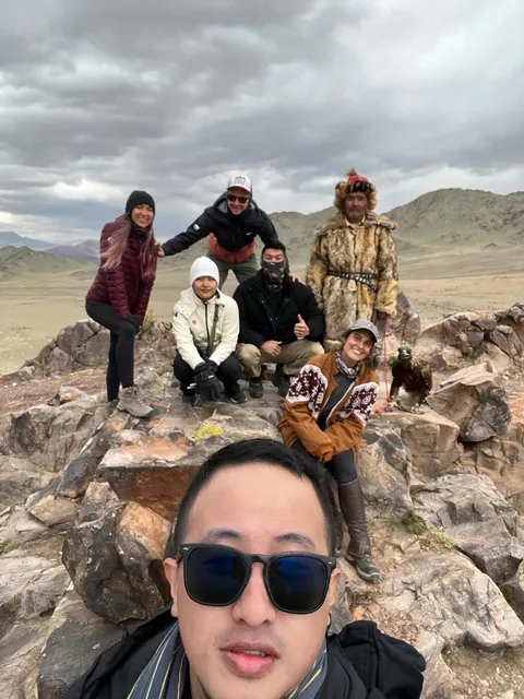 Group on the rocks with an eagle hunter