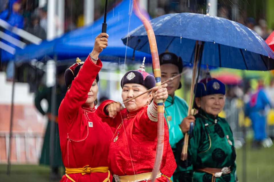 Women archers in red deel drawing their bows