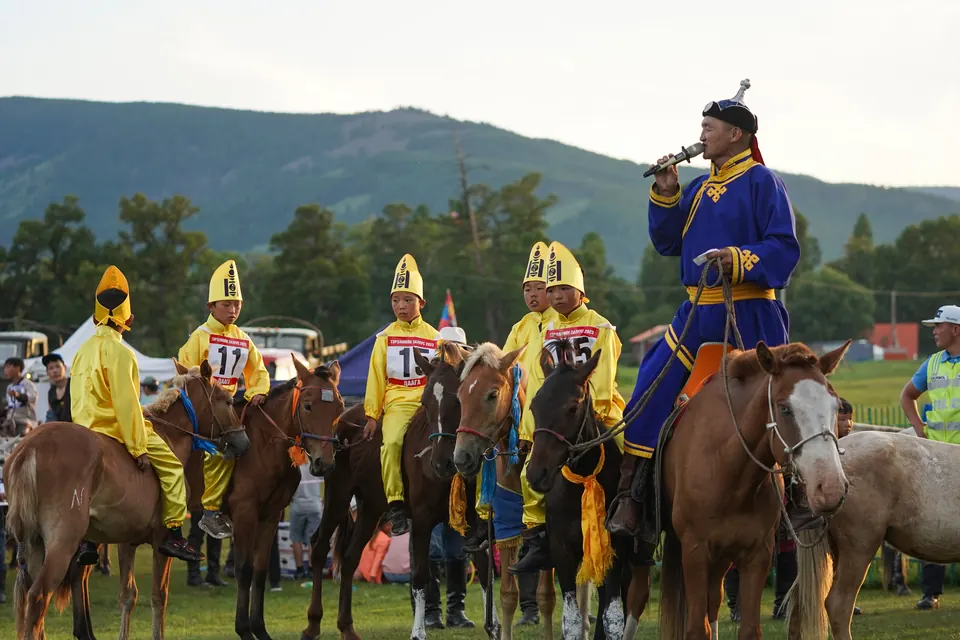 Riders in bright colours on horseback at Naadam