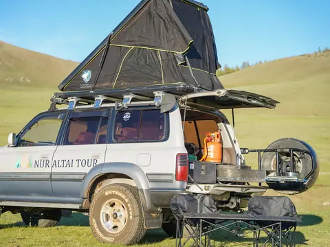 Silver Toyota Land Cruiser 80 with rooftop tent on the steppe