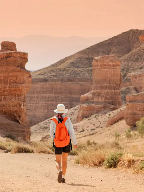 Hiker walking through a red rock canyon
